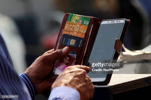 An attendant accepts payment through digital modes like debit and credit cards from a customer at a fuel station in New Delhi, India on February 17,...