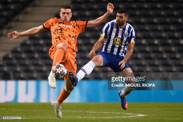Juventus' Turkish defender Merih Demiral vies with FC Porto's Iranian forward Mehdi Taremi during the UEFA Champions League round of 16 first leg...