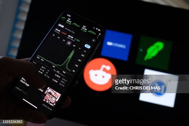 This illustration photo shows a person checking the three month GameStop stock graph on a smartphone on February 17, 2021 in Los Angeles as the...