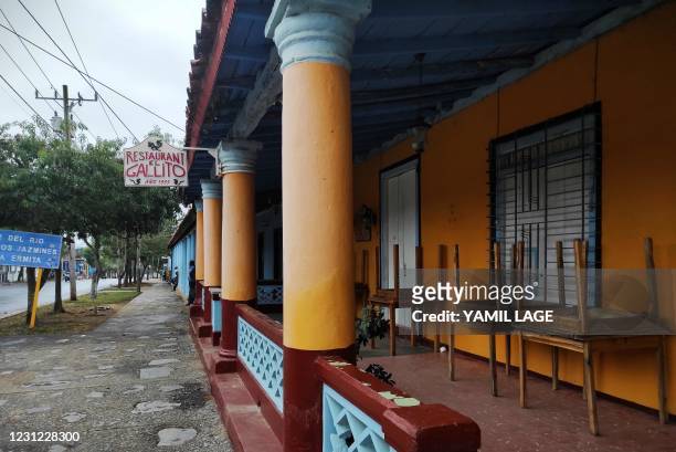 Man walks by a closed private restaurant in Vinales, Cuba, on January 28, 2021. - At the foot of the majestic rock formations of Vinales, the...