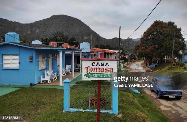 Car passes by a pivate house for rent in Vinales, Cuba, on January 28, 2021. - At the foot of the majestic rock formations of Vinales, the terraces...