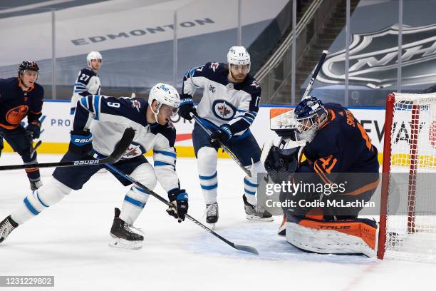 Goaltender Mike Smith of the Edmonton Oilers makes a save against Andrew Copp of the Winnipeg Jets at Rogers Place on February 17, 2021 in Edmonton,...