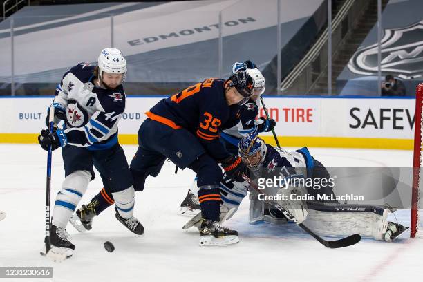 Alex Chiasson of the Edmonton Oilers battles against Josh Morrissey, Neal Pionk and goaltender Connor Hellebuyck of the Winnipeg Jets at Rogers Place...