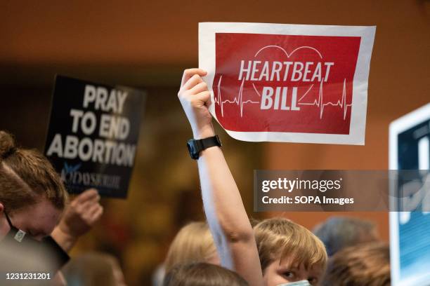 Demonstrator holding a placard saying 'Heart Beat Bill' during a press conference and protest by Democrats who walked out during a debate on an...