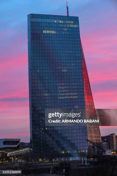 The facade of the headquarters of the European Central Bank is tinged by the colours of the rising sun in Frankfurt am Main, western Germany, on...