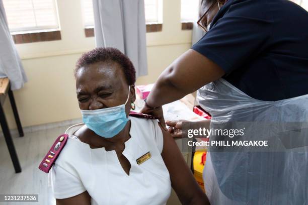 Healthcare worker reacts in pain as she receives a dose of the Johnson & Johnson vaccine against the COVID-19 coronavirus as South Africa proceeds...