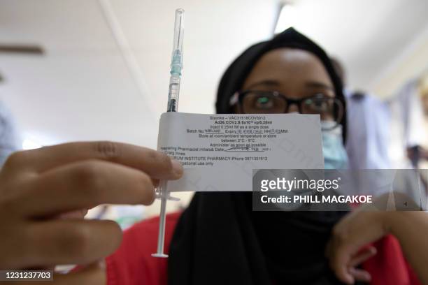 Healthcare worker holds a dose of the Johnson & Johnson vaccine against the COVID-19 coronavirus before administering it to another as South Africa...