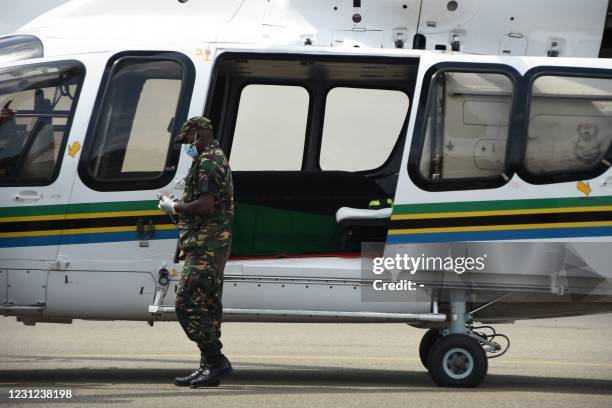 Soldier passes near the helicopter carrying the body of Zanzibar's Vice President, Maalim Seif Sharif Hamad before it takes off at Julius Nyerere...