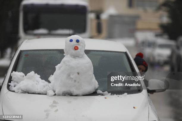 Snowman on a car after a snowfall in Ramallah, West Bank on February 18, 2021.