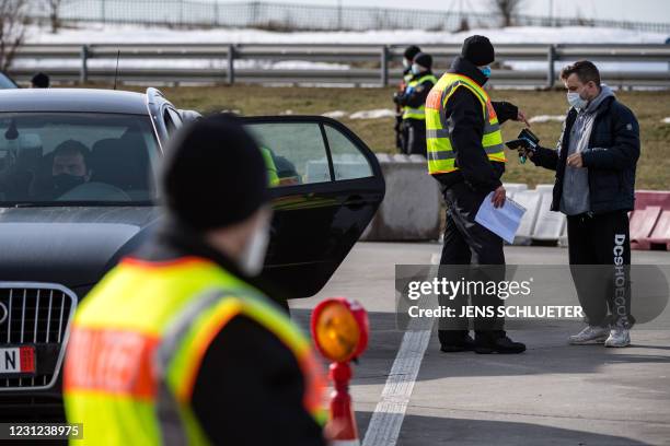 Officers of the Federal Police control a car driver at the German-Czech border in an attempt to stem the spread of the new coronavirus variants, in...