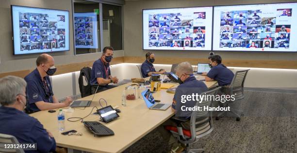 In this handout image provided by NASA, Members of NASAs Perseverance Mars rover management team meet via remote and in mission control, February 18,...