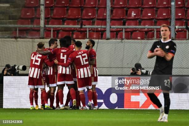 Olympiacos' Greek midfielder Andreas Bouchalakis celebrates with teammates after scoring a goal during the UEFA Europa League round of 32 first leg...