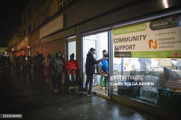 International students queue to collect food packages at the Newham Community Project food bank in east London on February 16, 2021. - "It's hard to...