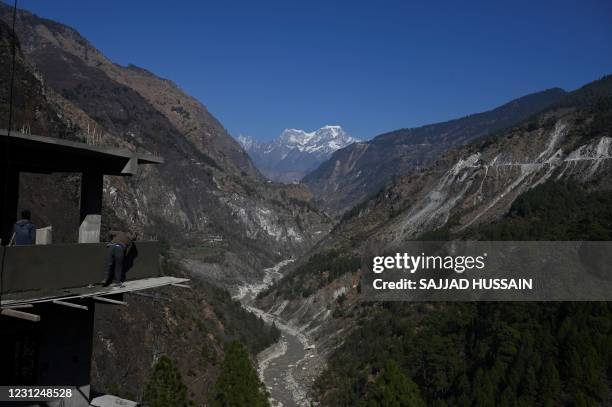 In this picture taken on February 11 a mason works at an under-construction building site on the edge of the mountain valley in Chamoli district of...