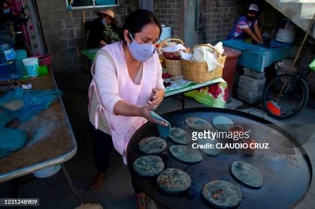 Ana, a member of the collective Mujeres de la Tierra, makes Mexican traditional tortillas in Milpa Alta, Mexico City, on February 16, 2021. - The...