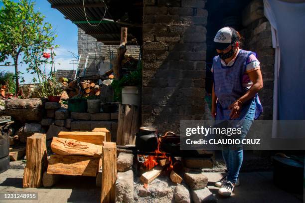 Leticia, a member of the collective Mujeres de la Tierra, works in the kitchen, in Milpa Alta, Mexico City, on February 16, 2021. - The collective...