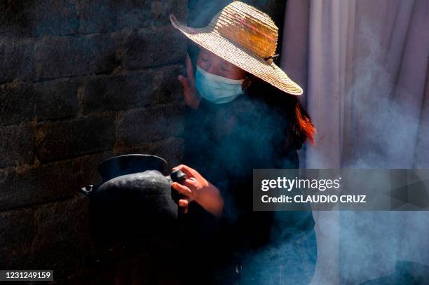 Alma, a member of the collective Mujeres de la Tierra, works in the kitchen, in Milpa Alta, Mexico City, on February 16, 2021. - The collective...