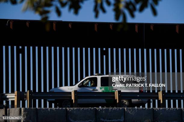 Border Patrol agent sits in a vehicle along a border wall near the US Customs and Border Protection San Ysidro Port of Entry at the US Mexico border...