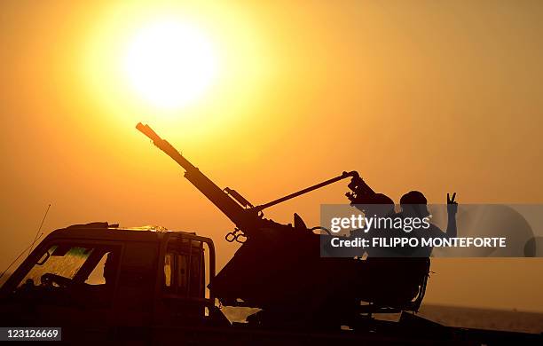 Libyan rebel flashes the victory sign while driving through a seaside road in Tripoli at sunset on August 26, 2011. Libyan rebels, who overran...