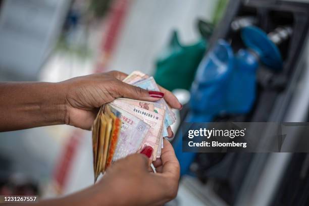 Worker checks real banknotes at a Petroleo Brasileiro SA gas station in Rio de Janeiro, Brazil, on Friday, Feb. 19, 2021. Petrobras declined after...