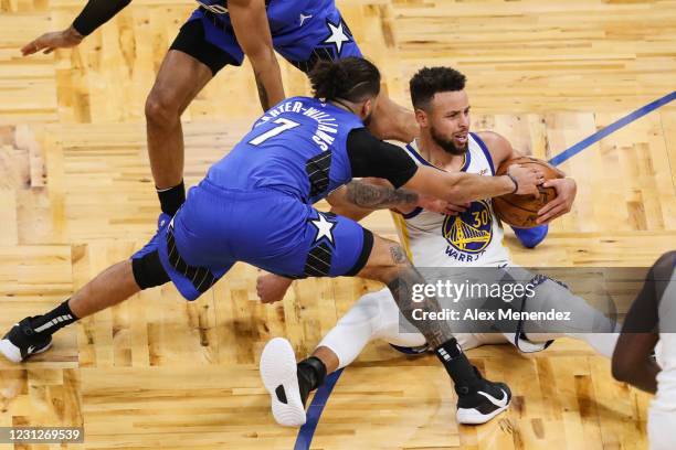 Michael Carter-Williams of the Orlando Magic and Stephen Curry of the Golden State Warriors fight for the ball during the first half at Amway Center...