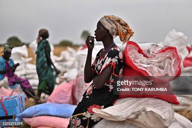 Villager who had volunteered to fetch gunny bags containing food rations from the site of an air drop takes a break at a village in Ayod county,...