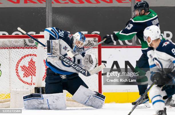 Goalie Laurent Brossoit of the Winnipeg Jets stops a redirected puck off the stick of Bo Horvat of the Vancouver Canucks during NHL hockey action at...