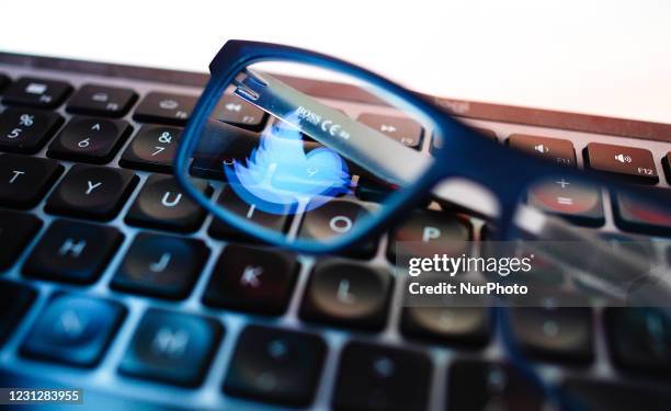 The Twitter logo is seen reflected in a pair of glasses on a keyboard in Warsaw, Poland on February 20, 2021.