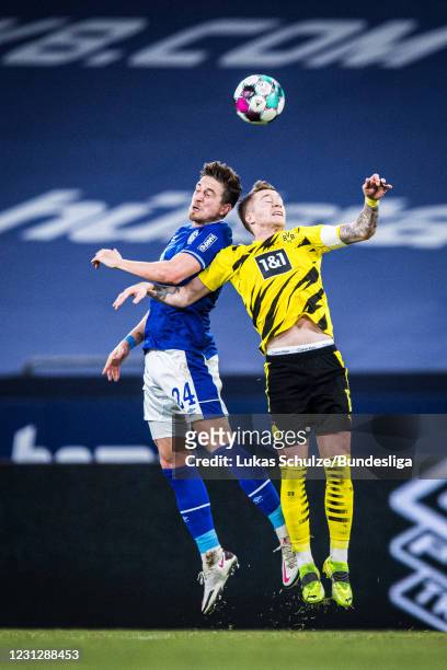 Bastian Oczipka of Schalke and Marco Reus of Dortmund in action during the Bundesliga match between FC Schalke 04 and Borussia Dortmund at...
