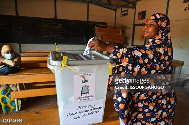 Woman casts her vote in a classroom at a polling station in Niamey on February 21, 2021 during Niger's second round of the presidential election. -...