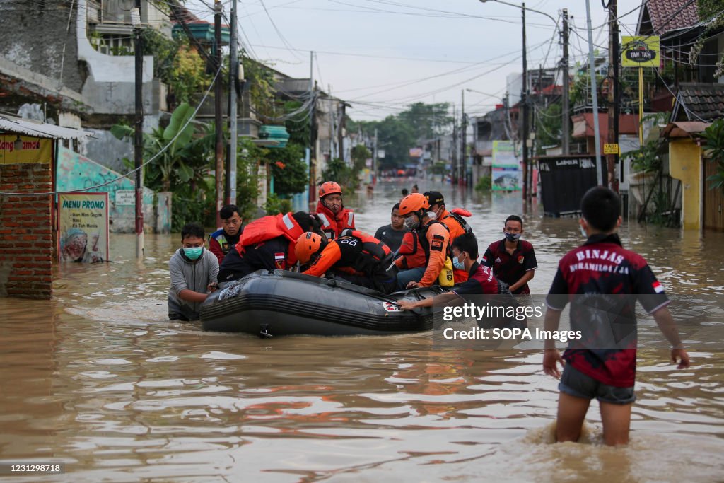 Volunteers carry flood victims using rubber boats during the...
