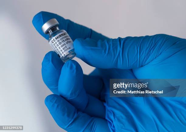 Member of the medical staff holds a vial of the Pfizer-Biontech Comirnaty vaccine at a mobile vaccination center situated in a modified bus in...