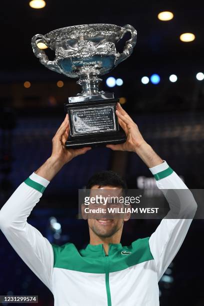 Serbia's Novak Djokovic poses with the Norman Brookes Challenge Cup trophy following his victory against Russia's Daniil Medvedev in their men's...
