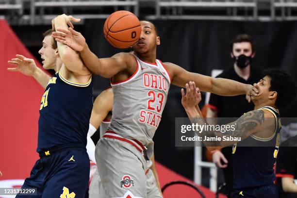 Austin Davis of the Michigan Wolverines, left, and Zed Key of the Ohio State Buckeyes battle for control of a rebound as Key holds off Eli Brooks of...