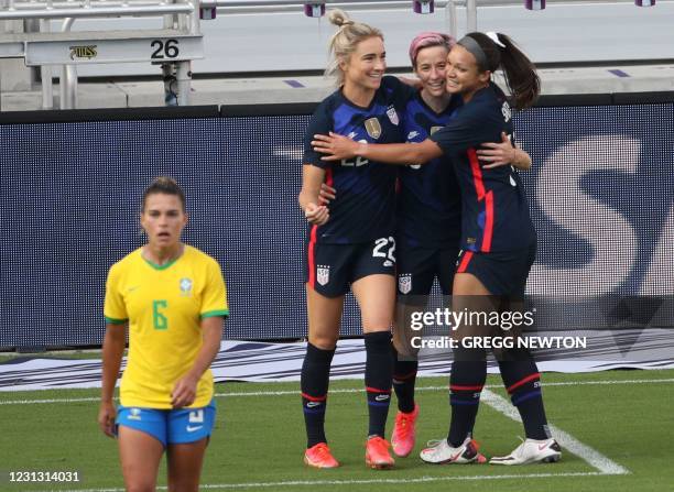 Forward Megan Rapinoe celebrates after scoring a second half goal against Brazil with teammates Kristie Mewis and Sophia Smith during their...