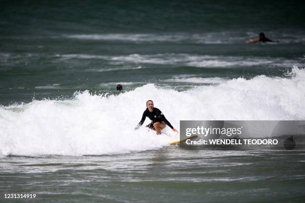 This picture taken on January 23, 2021 shows a resident surfing on Crowdy Bay National Park at Port Macquarie, some 127 kilometres northeast of...