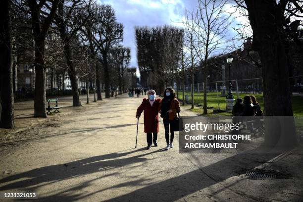Year-old retiree Genevieve Dupaquier walks with student Dilara Ekinci during a stroll organised by the 'Paris en compagnie' association, at the...