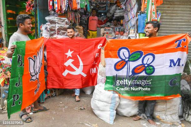 Shopkeepers putting up flags of various political parties to display for sale ahead of assembly elections in Bengal, in Kolkata, India, on February...