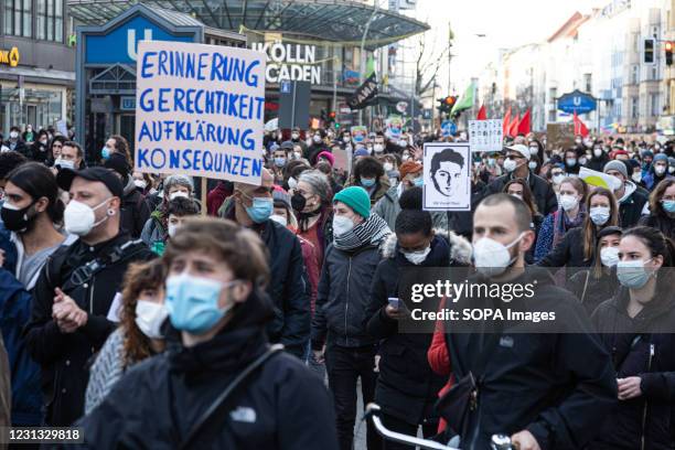 Several protesters wearing masks march while holding placards and portraits of the victims of the Hanau terror attack. On the first anniversary of...