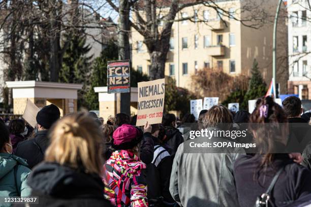 Protester is seen holding a placard saying "Never Forget" during the protest. On the first anniversary of the far-right terror attack in Hanau,...