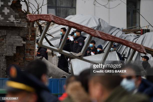 Investigators stand on the rubble of a restaurant which was destroyed in an explosion, near the Zhongnanhai leadership compound in Beijing on...