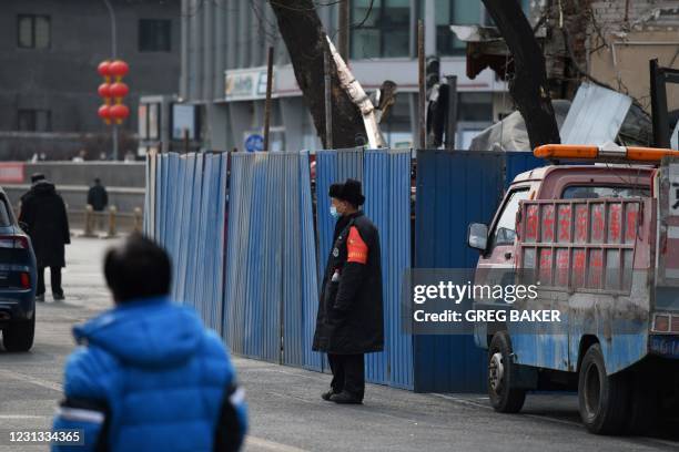 Security guard stands outside the remains of a restaurant which was fenced off after it was destroyed in an explosion, near the Zhongnanhai...