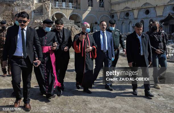 Archbishop of the Archeparchy of Mosul Najib Mikhael Moussa and Father Raed Adel and Niniveh Governor Najim al-Jabouri escort the members of the...