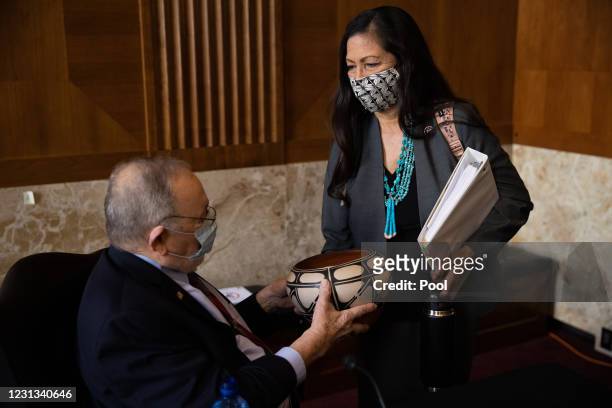 Rep. Deb Haaland , nominee for Secretary of the Interior, delivers a gift to Rep. Don Young at her confirmation hearing before the Senate Committee...