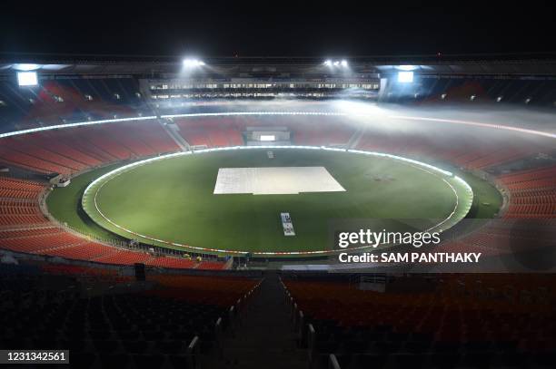 This photograph taken on February 23, 2021 shows fogging underway as a precautionary measure at the Sardar Patel Stadium, the world's biggest cricket...