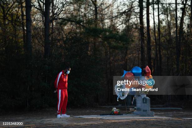 Bianca Dorsey visits the gravesite of Ahmaud Arbery during a candlelight vigil at New Springfield Baptist Church on February 23, 2021 in Waynesboro,...