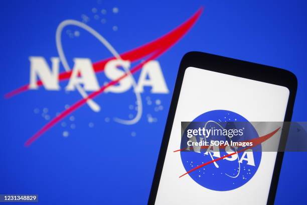 In this photo illustration, NASA logo is seen displayed on a smartphone and pc screen.