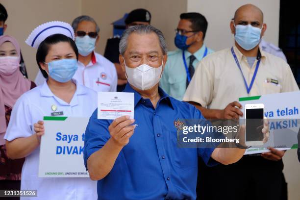 Muhyiddin Yassin, Malaysia's prime minister, displays the MySejahtera app during a news conference after receiving the Pfizer-BioNTech Covid-19...
