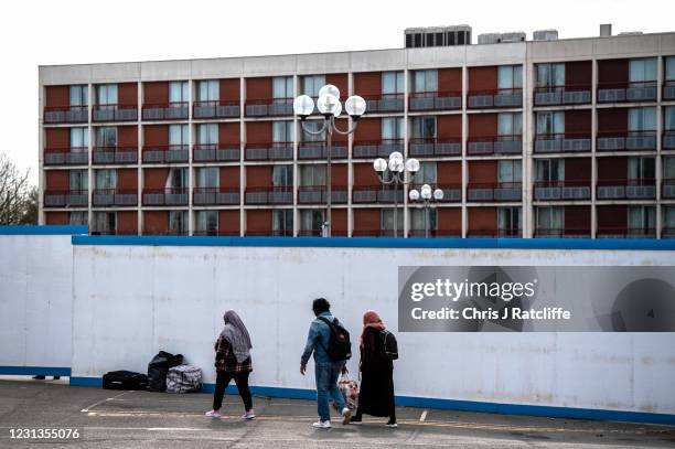 Asylum seekers enter the Crowne Plaza hotel through an exterior perimeter wall that has been installed whilst they stay at the hotel on February 24,...