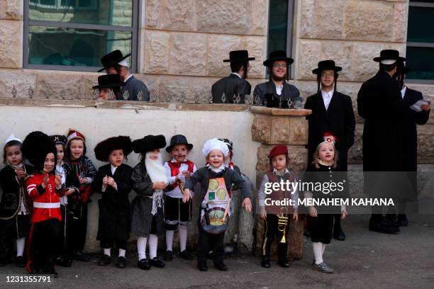 Ultra-Orthodox Jewish children dressed in costumes celebrating Purim walk in a yard at their school, one day ahead of the official holiday, in the...